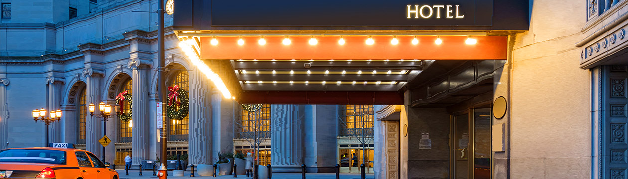 Photo of a hotel entrance and a waiting taxi cab in downtown Cleveland during the winter holidays.